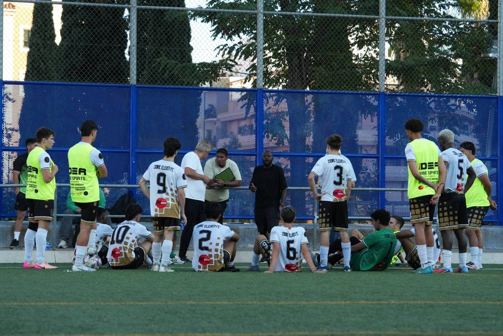 Entrenador de Zodiac Eleven dando instrucciones a la plantilla desde la banda